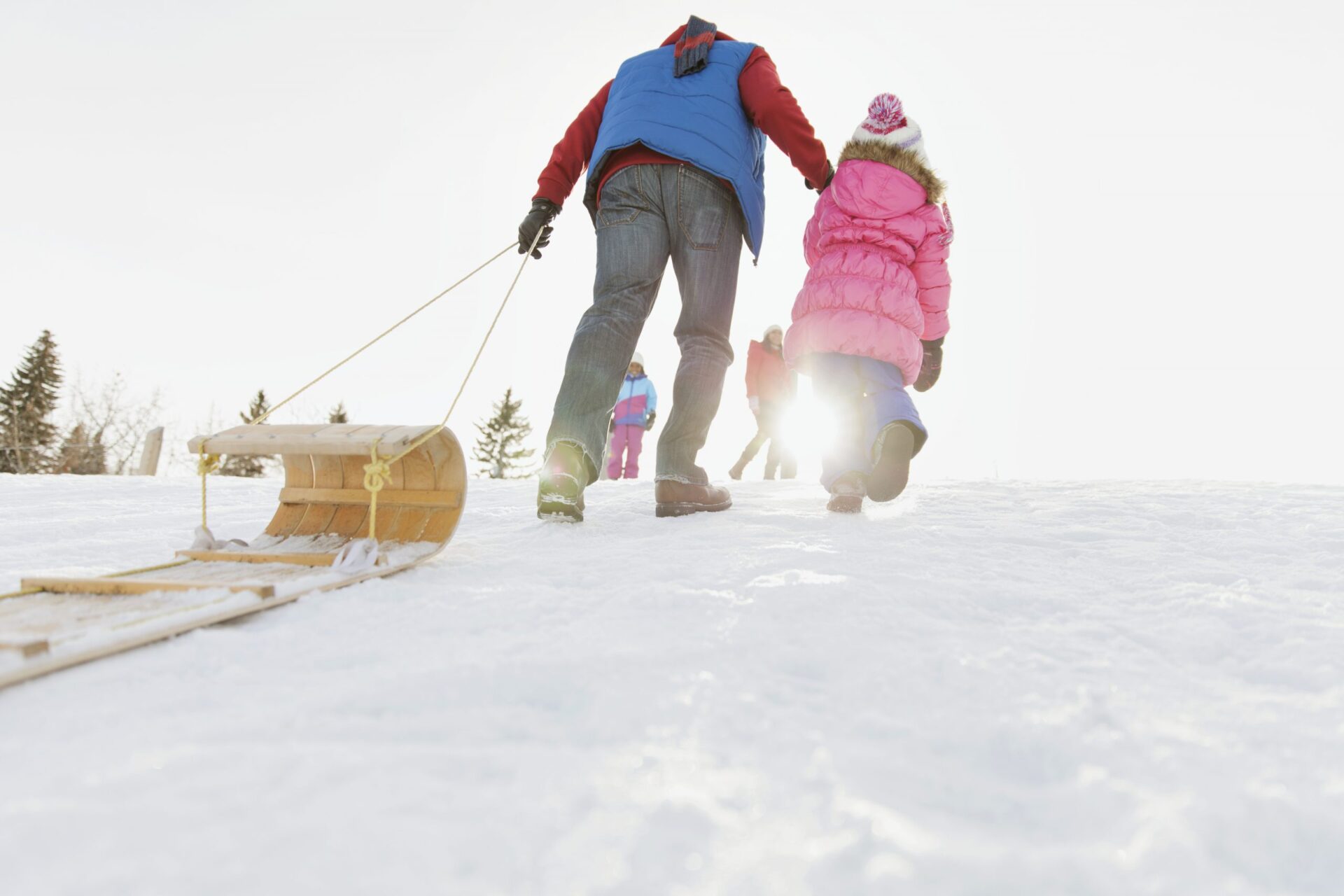 Low angle view of man pulling toboggan outdoors