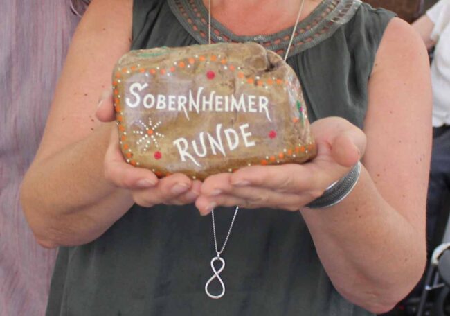 Stein mit der Aufschrift "Sobernheimer Runde", der von einer Frau gehalten wird, deren Kopf nicht zu sehen ist. Foto: Simone Mager