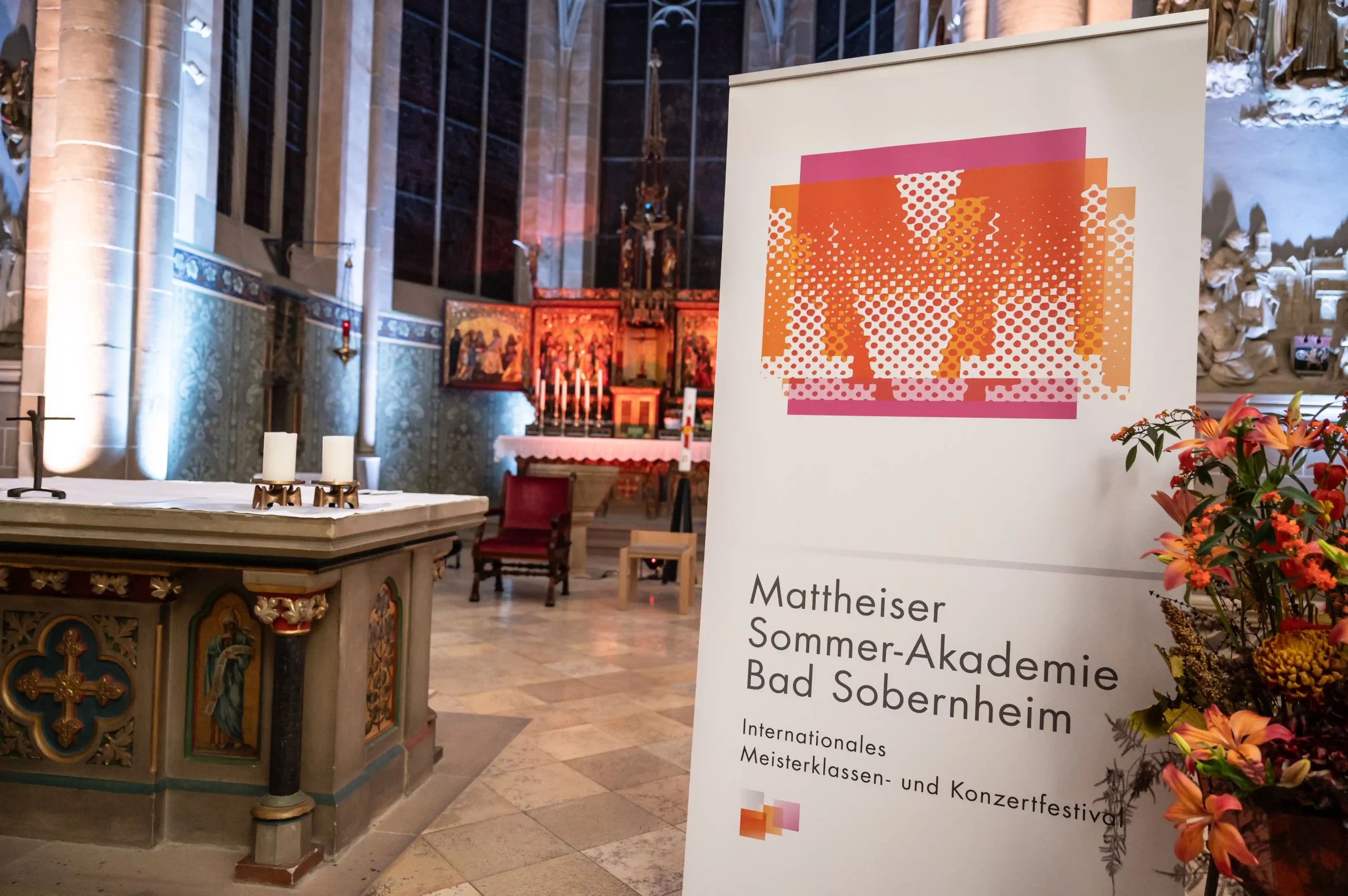 Roll up der Mattheiser Sommerakademie vor kirchlichem Hintergrund