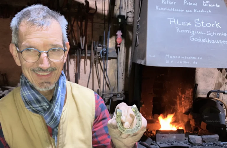 lex Stork zeigt ein Hufeisen in der Remigius-Schmiede im Rheinland-Pfälzischen Freilichtmuseum