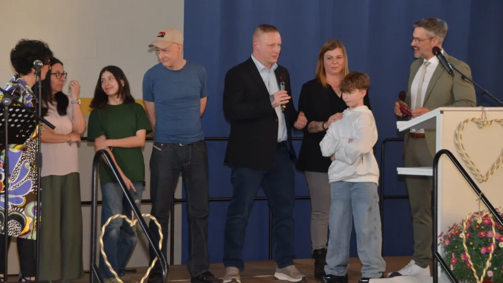 Kinder und ihre Familien, die vom Förderverein unterstützt wurden, auf der Jubiläumsbühne mit Moderator Stefan Brockelmann.