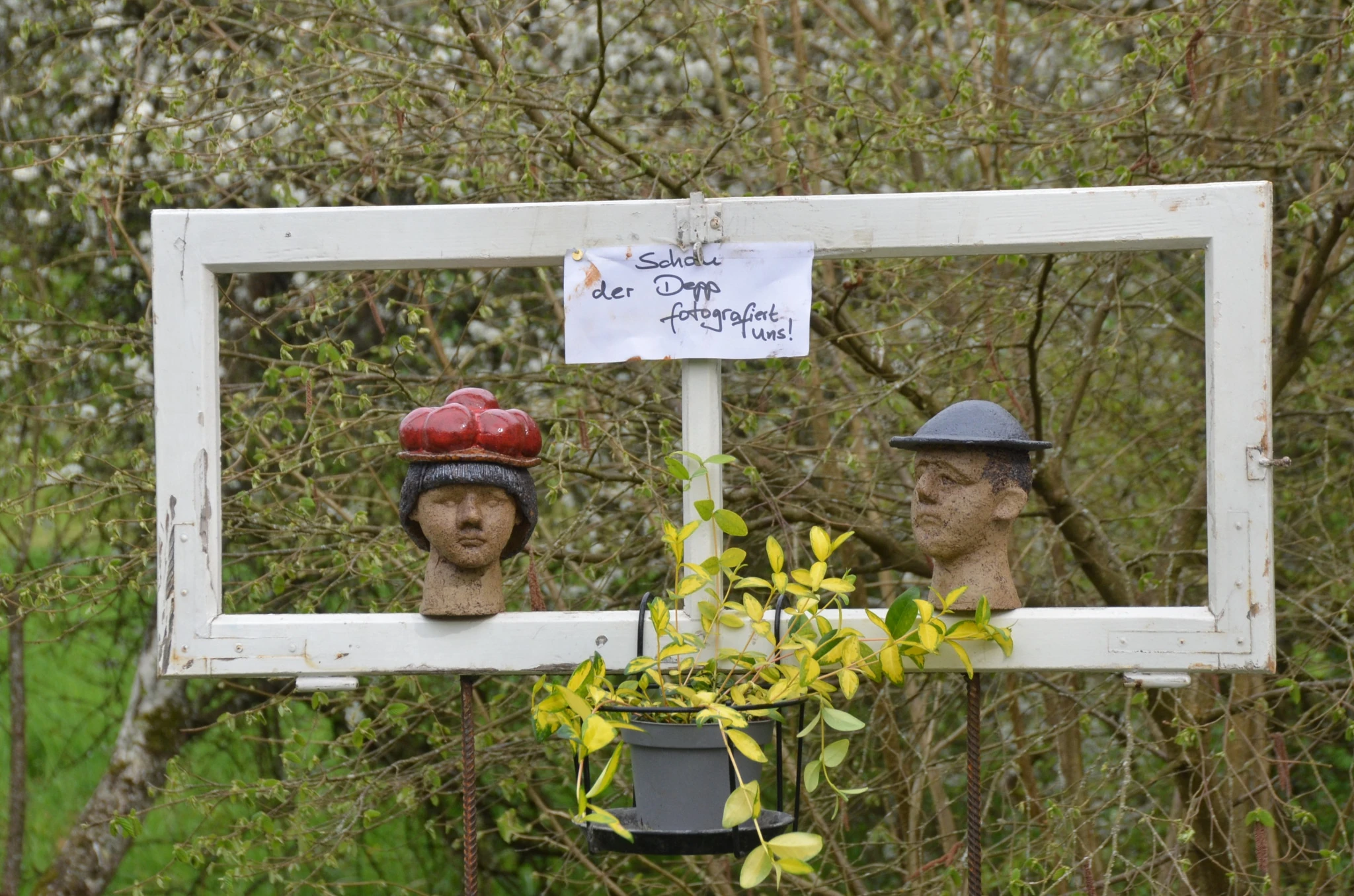 Dekorativer Bilderrahmen mit zwei Köpfen aus Ton.