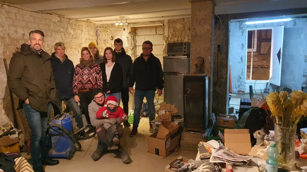 Stefan Bockelmann und Jutta Bartels zusammen mit einer Familie im kaputten Keller der Familie nach der Katastrophe.